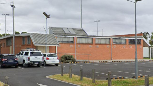 Altona Hockey Club pavilion viewed from Sugar Gum Drive with car park in foreground