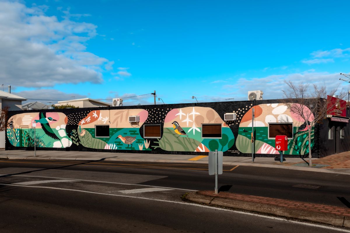 A street art mural by artist Sarah Allen featuring birds and local wildlife in a water setting